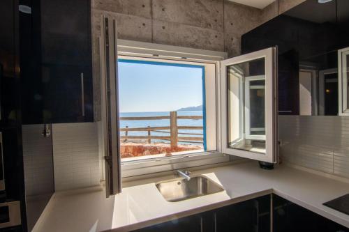 cocina con ventana y vistas al océano en Villa Alex, en La Isleta del Moro