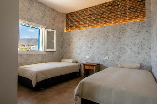1 dormitorio con 2 camas y ventana en Villa Alex, en La Isleta del Moro