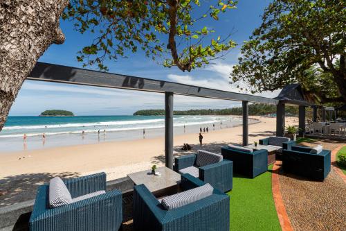 a view of a beach with blue chairs and a table at The Boathouse Phuket-SHA Plus in Kata Beach