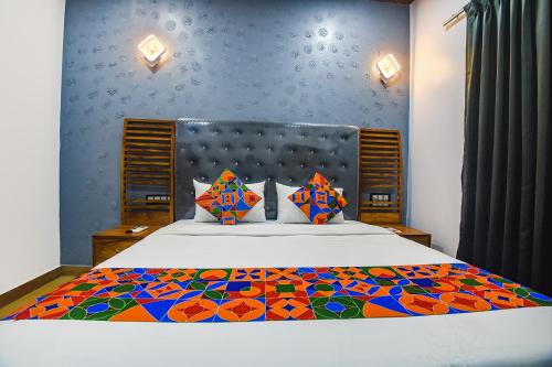 MarmagaoにあるFabHotel Bay Boutique By Foxtaleのベッドルーム1室(大型ベッド1台、カラフルな掛け布団付)