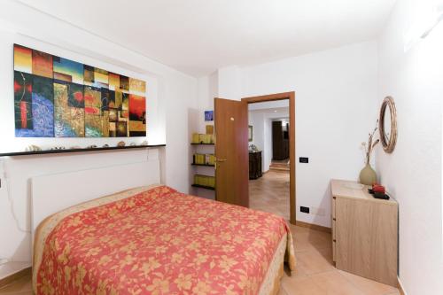 een slaapkamer met een bed en een schilderij aan de muur bij Casa Elena in Moneglia