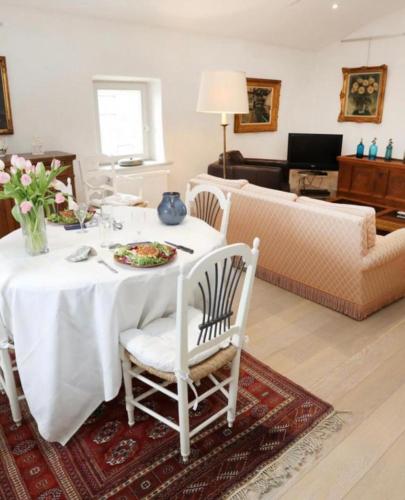 a living room with a white table and chairs at Au l’heur de mon cloché in Cléon-dʼAndran