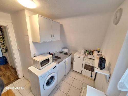 a small kitchen with a washing machine and a microwave at Wohnung nah zur Uniklinik in Würzburg