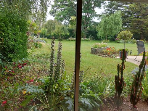 Elle offre une vue sur le jardin depuis sa fenêtre. dans l'établissement Le Jardin de Wéléat, à Valognes