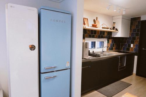 a blue refrigerator in a kitchen with a sink at Blue Casa in Seogwipo