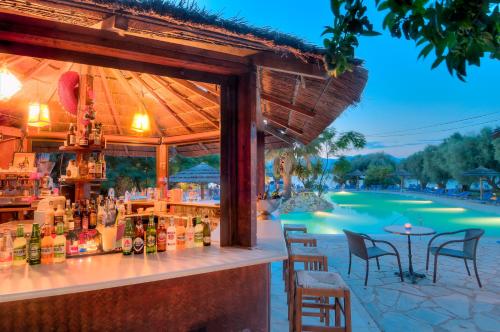 a bar at a resort with a view of a pool at Florida Blue Bay Resort & Spa in Psathopirgos