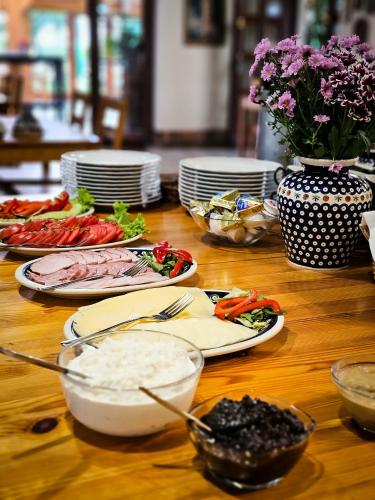 a wooden table with plates of food on top of it at Gościniec Gryszczeniówka & SPA in Wargowo