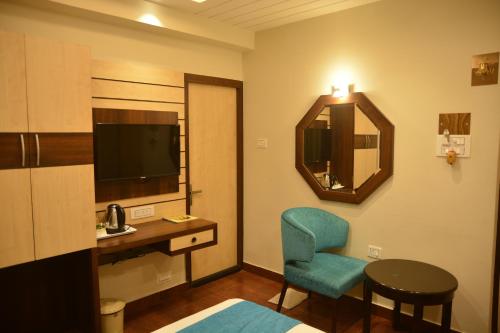 a hotel room with a desk and a chair and a mirror at Hotel Avenue Plaza, Serampore - N S Avenue 