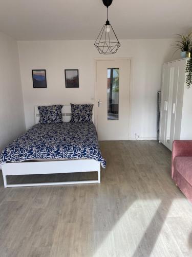 une chambre avec un lit avec un couvre-lit bleu et blanc dans l'établissement GRAND STUDIO avec balcon -4 PERSONNES-DISNEYLAND- PARIS a 10 minutes, à Thorigny-sur-Marne