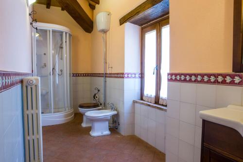a bathroom with a toilet and a shower and a sink at Villa Orizzonte - Homelike Villas in Todi