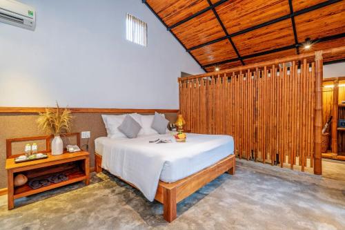 a bedroom with a bed and a wooden wall at M Village Phu Quoc in Phu Quoc