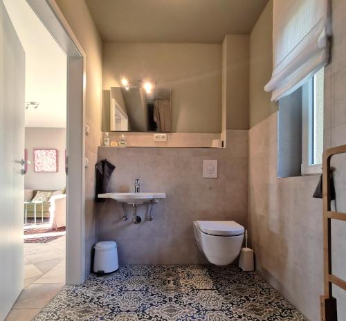 La salle de bains est pourvue de toilettes et d'un lavabo. dans l'établissement Landhaus Arcadia in Paretz, à Ketzin/Havel