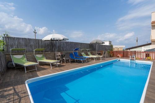 a swimming pool with chairs and a table next to a fence at Villa Dario in Castellana Grotte