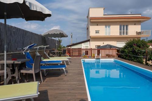a swimming pool with tables and chairs and a building at Villa Dario in Castellana Grotte