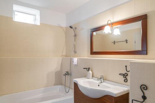 a bathroom with a sink and a tub and a mirror at Villa Resperi in Gonia