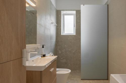 a bathroom with a sink and a toilet and a window at Villa Resperi in Gonia