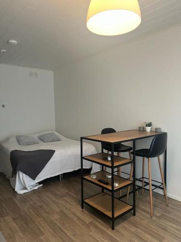 Modern apartment nearby Kerava2 في كيرافا: غرفة نوم بسرير وطاولة وكراسي