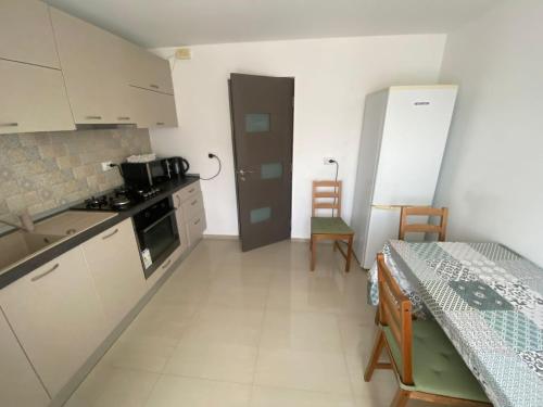 a kitchen with white cabinets and a table in a room at Apartament Central Suceava in Suceava