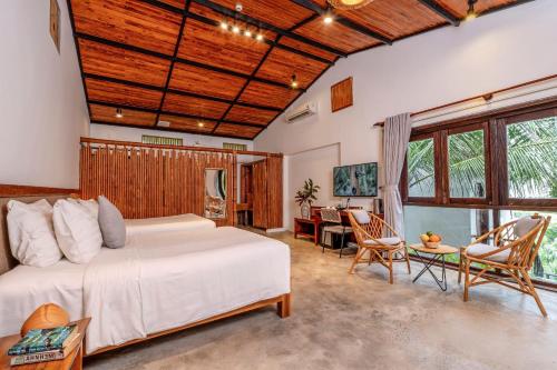 a bedroom with a bed and a table and chairs at M Village Phu Quoc in Phu Quoc