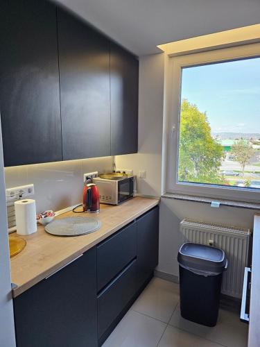 a kitchen with a counter with a microwave and a window at Apartment SAND - Entry with PIN 0 - 24h, Luxury massage chair,Infrared sauna,FREE CANCELLATION 24 hours before Check In, Premium pillows and mattress in Slavonski Brod