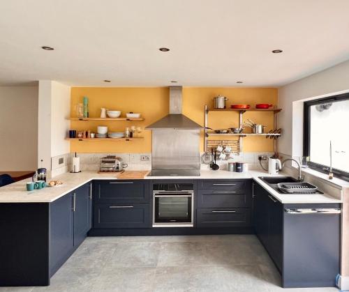 a kitchen with black cabinets and a stove top oven at The Annex, Escape to the Country in Salcombe