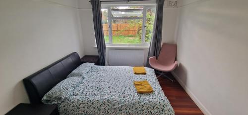 a small bedroom with a bed and a window at Ritzs place in Northolt