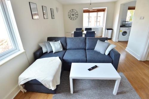 a living room with a blue couch and a table at Luxury 2 BR Fully Furnished Flat in Crawley - 2 FREE Parking Spaces in Crawley