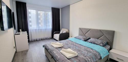 1 dormitorio con 1 cama y 1 silla en Квартира біля озера ЖК Панорама en Ternopilʼ