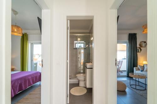 a bedroom with a purple bed and a bathroom at Villaceixe - cute living in Odeceixe in Odeceixe