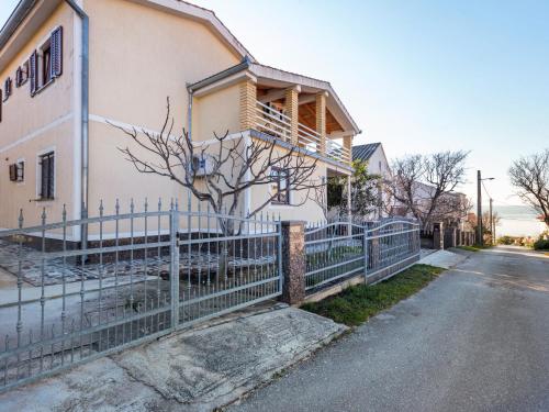 una casa blanca con una valla al lado de una calle en Beautiful Apartment in Jasenice near Sea en Jasenice