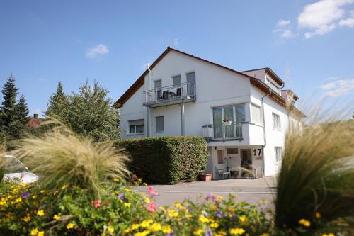 a white house with a garden in front of it at Schubart Apartments in Bietigheim-Bissingen
