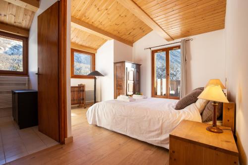 um quarto com uma cama num quarto com tectos em madeira em Chalet du Golf 618 - Happy Rentals em Chamonix-Mont-Blanc