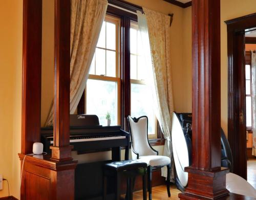 um quarto com um piano, uma cadeira e uma janela em Beautiful Victorian house, Great Views, free parking em Boston