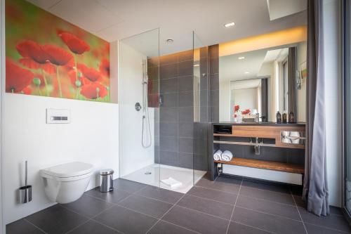 a bathroom with a shower and a toilet and a sink at LAGO hotel & restaurant am see in Ulm