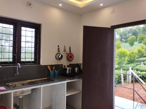 uma cozinha com um balcão preto e uma janela em SHI's Vagamon Hill Retreat- Private villa on Hills em Vagamon