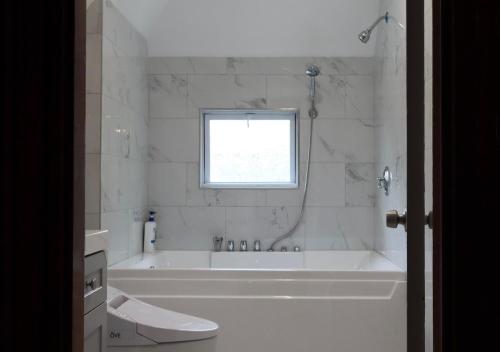 a white bathroom with a tub and a window at Beautiful Victorian house, Great Views, free parking in Boston