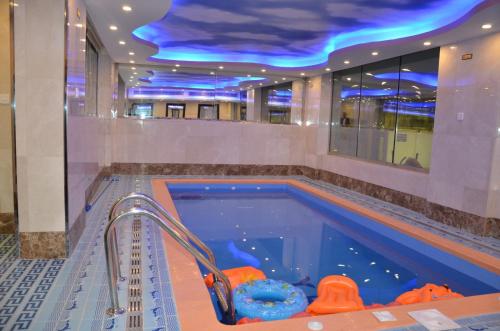 una piscina en un edificio con techo azul en جولدن أرمادا جيزان Golden Armada Hotel, en Jazan