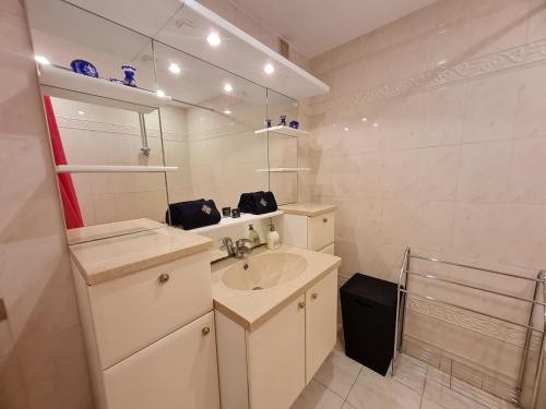 een witte badkamer met een wastafel en een spiegel bij T3 LE PRESIDENT PROCHE PINEDE in Antibes