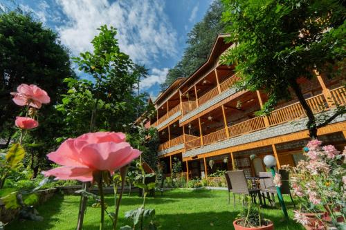 a garden in front of a building with flowers at Hotel Negi's Mayflower A heritage Since 1965 in Manāli