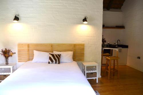 a bedroom with a large white bed with two pillows at Private Studio with Kitchenette in Cape Town