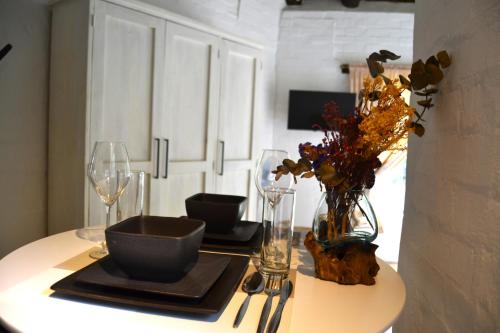 a table with glasses and a vase of flowers on it at Private Studio with Kitchenette in Cape Town
