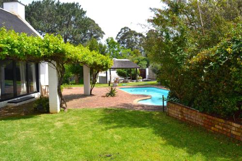 a yard with a swimming pool and a house at Private Studio with Kitchenette in Cape Town