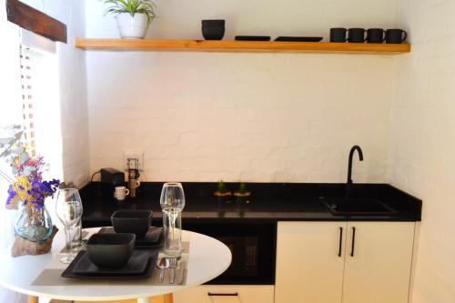 a kitchen with a table with wine glasses on it at Private Studio with Kitchenette in Cape Town