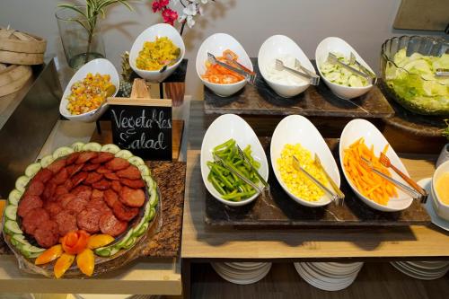 a buffet with bowls of food and a plate of food at Coron Westown Resort in Coron