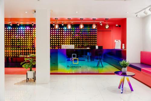 a brightly colored room with a table and chairs at Budacco The Living Place in Bangkok