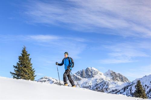 a man is skiing down a snow covered slope at nawu apartments & Restaurant in Hermagor