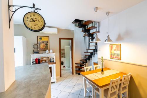 a kitchen and dining room with a clock on the wall at A casa di Vale in Lodi