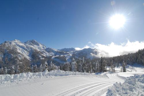 a snow covered ski slope with the sun in the sky at nawu apartments & Restaurant in Hermagor