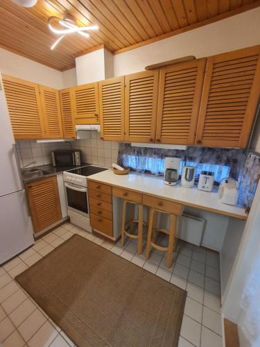 a kitchen with wooden cabinets and a counter top at Rokua Ahveroinen A3 in Rokua