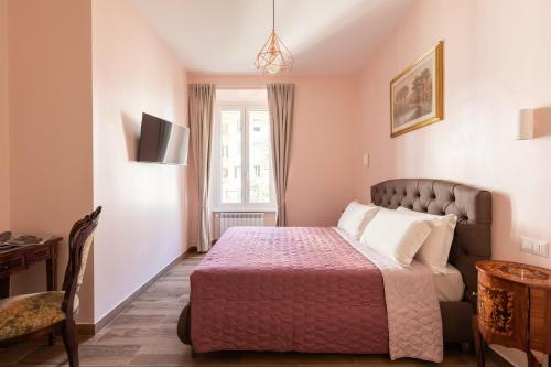a bedroom with a bed and a desk and a window at Queen Meg Roma in Rome